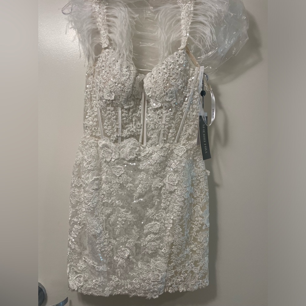 White sequence mini dress with feathered detailing on the straps